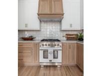 A beautifully designed kitchen featuring custom cabinetry, a professional range, and stylish accents at 1532 Sea Palms Cres, Mount Pleasant, SC 29464