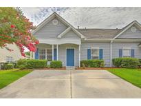 Charming gray home with blue shutters and a well-manicured front yard creates a welcoming curb appeal at 159 Townsend Way, Summerville, SC 29483