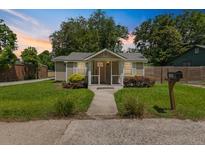 Charming single-story home features a well-manicured lawn and inviting front porch with a mailbox on the side at 1940 Orangeburg St, North Charleston, SC 29405