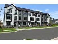 View of new townhomes with a clean street, grassy lawns, and neutral color schemes at 203 Somerset Acres Dr, Summerville, SC 29486