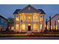 Charming two-story home with a double porch, manicured lawn, and inviting curb appeal at dusk at 2038 Sea Water Dr, James Island, SC 29412