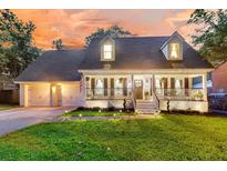Charming two-story home featuring a welcoming front porch, well-manicured lawn, and attached two-car garage at 205 Towhee Dr, Summerville, SC 29485