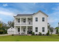 Charming two-story home boasting a double front porch, well-manicured lawn, and attached garages at 2408 Bent Oak Rd, Mount Pleasant, SC 29466
