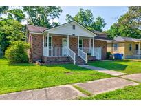 Charming brick home with a inviting front porch and a well-manicured lawn at 2657 Oregon Ave, North Charleston, SC 29405