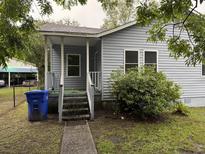 Charming home featuring a covered front porch, a well-maintained lawn and light blue siding at 2749 E Surrey Dr, North Charleston, SC 29405