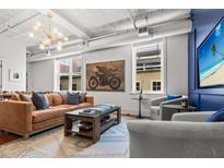 Bright living room with leather sofa, decor pillows, and stylish light fixture at 4 Beaufain St # 207, Charleston, SC 29401