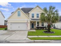 Charming two-story home featuring a well-manicured lawn, two-car garage, and a classic blue front door at 411 Topcrest Ln, Moncks Corner, SC 29461