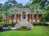 Beautiful brick home features a grand entrance with dual staircases and well-manicured landscaping at 4272 Persimmon Woods Dr, Charleston, SC 29420