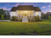 Inviting two-story home with a charming front porch and manicured lawn at 4808 Wilson Rd, Meggett, SC 29449