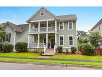 Charming two-story home featuring a double porch, manicured lawn, and inviting curb appeal at 5242 E Dolphin St, North Charleston, SC 29405