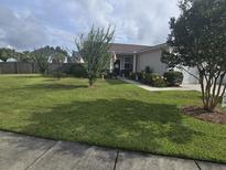 Charming single-story home with well-manicured lawn, flowerbeds, and walkway leading to the front door at 605 Grassy Hill Rd, Summerville, SC 29483