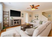 Bright living room featuring a sectional sofa, large TV, and a ceiling fan at 708 Professor Dr, Ladson, SC 29456