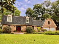 Charming brick home featuring a well-maintained lawn, mature landscaping, and inviting curb appeal at 8 Brisbane Dr, Charleston, SC 29407
