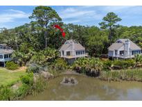 Charming coastal home with a spacious deck overlooking a tranquil pond surrounded by lush greenery at 811 Treeloft Trce, Seabrook Island, SC 29455
