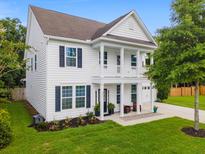 Charming two-story home features a welcoming front porch and well-manicured lawn at 9713 Cutleaf Dr, Ladson, SC 29456