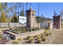 French Quarter Creek community entrance with brick pillars, sign, and well-maintained landscaping at 104 Wild Orchid Way, Huger, SC 29450
