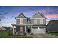 Charming two-story home with a covered front porch and attached garage, perfect for Gathering living at 107 Cotton Blossom Way, Summerville, SC 29485