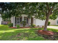 Charming brick-accented home with a well-manicured lawn and mature tree providing shade at 112 Mayfield Dr, Goose Creek, SC 29445