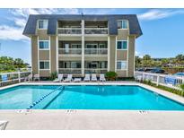 Beautiful condominium complex featuring a large shimmering pool with ample space for sunbathing and relaxation at 1400 Ocean Blvd # 106B, Isle of Palms, SC 29451