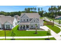Beautiful two-story home with a manicured lawn, a charming front porch, and a well-kept garden at 1950 Parish House Cir, Johns Island, SC 29455
