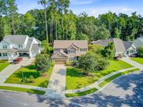Beautifully landscaped two-story home on a cul-de-sac with mature trees and a well-manicured lawn at 206 President Cir, Summerville, SC 29483