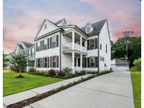 Charming two-story home featuring a balcony, manicured landscaping, and a detached garage at 2234 Kemmerlin St, Johns Island, SC 29455