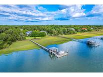 Stunning aerial view of waterfront homes, private docks, and lush green surroundings under a partly cloudy sky at 2287 Shoreline Dr, Johns Island, SC 29455