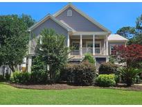 Charming two-story home with well-manicured lawn and lush landscaping, including a covered porch with white columns at 2517 Charter Oaks Dr, Mount Pleasant, SC 29466