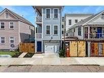Charming two-story home with a blue exterior, a garage, and a small landscaped front yard at 4 Line St, Charleston, SC 29403