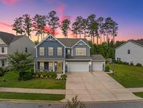 Charming two-story home with a three car garage, landscaped yard and inviting front porch at 443 Coopers Hawk Dr, Summerville, SC 29483