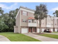 Charming townhome with a one car garage and a well manicured lawn, with a palm tree at 4630 Palm View Cir, North Charleston, SC 29418