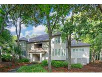 Inviting multi-story home with a serene setting surrounded by lush greenery and mature trees, and a charming facade at 4856 Green Dolphin Way # Share 5, Kiawah Island, SC 29455