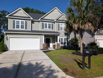 Charming two-story home boasts a manicured lawn, two car garage, and appealing architectural details at 5256 Mulholland Dr, Summerville, SC 29485