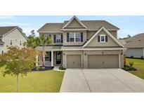 Charming two-story home featuring a brick facade, a well-manicured lawn and a spacious driveway at 528 Fern Tree Dr, Summerville, SC 29486