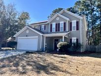 Charming two-story home with gray siding, red shutters, two car garage, and a well-maintained front lawn at 7277 Sweetgrass Blvd, Hanahan, SC 29410
