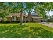 Charming brick home featuring a well-manicured lawn and mature trees for shade at 8204 Pleasant Ridge Dr, Charleston, SC 29420