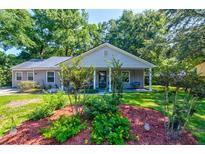 Charming single-story home with a manicured lawn and inviting front porch swing at 102 Cottonwood Dr, Summerville, SC 29483