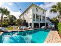 Inviting backyard pool with ample seating areas and sunny skies at 109 Carolina Blvd, Isle of Palms, SC 29451