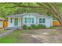 Charming single-story home featuring a green door, white brick, and mature trees in the front yard at 1188 Camden St, North Charleston, SC 29405