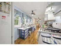 Functional kitchen with a gas range, blue-trimmed windows, and vinyl flooring at 145 Ravenell Dr, Saint Stephen, SC 29479