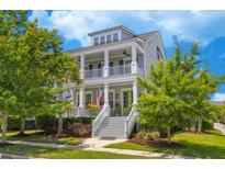 Beautiful two-story home featuring double porches and a welcoming entrance with manicured landscaping at 1530 Willtown St, Daniel Island, SC 29492