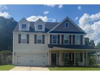 Charming two-story home with front porch, garage, shuttered windows and landscaped front yard at 158 Balsam Cir, Summerville, SC 29485