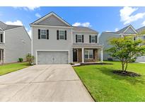 Charming two-story home with a manicured lawn, stone accents, and an attached two-car garage at 158 Netherfield Dr, Summerville, SC 29486