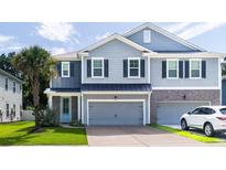 Charming two-story home features a well-maintained lawn, gray siding and attached two-car garage at 1630 Mermentau St, Mount Pleasant, SC 29466