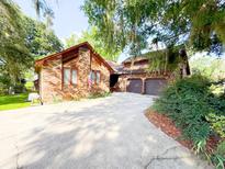 Charming brick home boasts an attached two-car garage and a spacious driveway, all nestled under lush, mature trees at 1807 Perch Rd, Moncks Corner, SC 29461