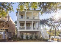 Two-story home with double balconies, white columns, brick foundation and staircase to main level at 2356 Hut Creek Rd, Johns Island, SC 29455
