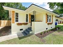Charming home featuring fresh paint, custom wood shutters, and flower boxes creating inviting curb appeal at 2704 Orchid Ave, North Charleston, SC 29405