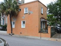 A charming orange house with white trim and a palm tree in front, Charleston, SC at 30 Society St, Charleston, SC 29401