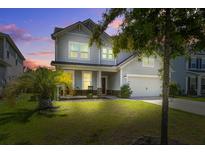 Charming two-story home with landscaped yard, covered porch and two-car garage at twilight at 357 Beachgrass Ln, Summerville, SC 29486