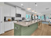 Bright open kitchen featuring granite countertops, stainless steel appliances, and an island overlooking the living area at 3789 Tupelo Branch Row, Mount Pleasant, SC 29429
